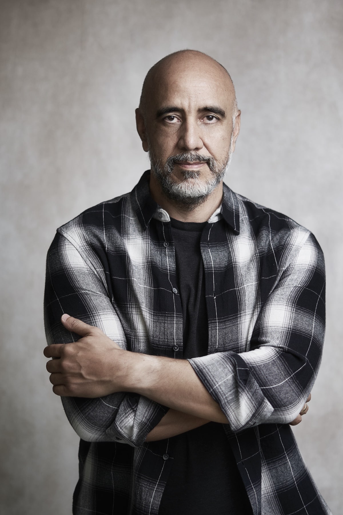 portrait of photographer with a grin wearing a plaid shirt